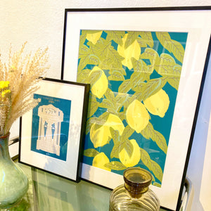 affiche citron format 40 x 50 cm décorant un salon, accompagné d'un bouquet de fleurs séchées et d'un flacon vintage de couleur brun fumé.